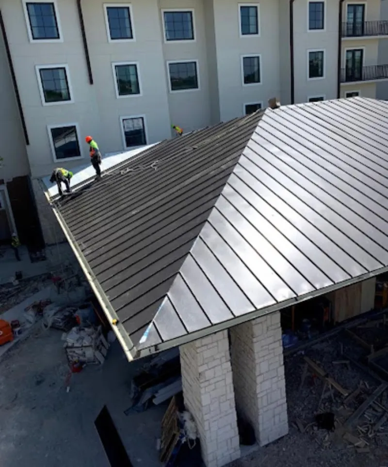 Crew installing standing seam metal roof panels on a commercial project in Memphis